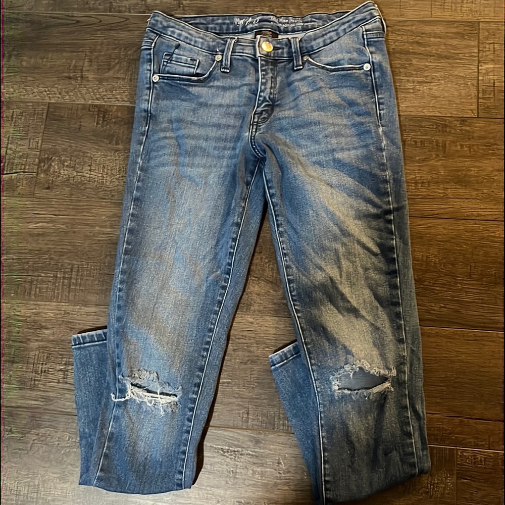 Skinny blue jeans, ripped at knee level.